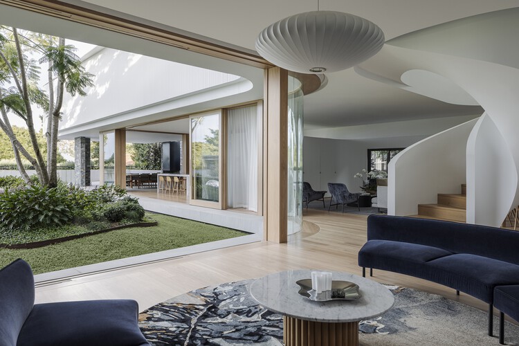Дом-бумеранг / Joe Adsett Architects — фотография интерьера, гостиная, стол, стул, окна