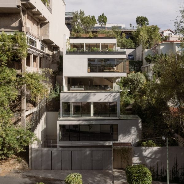 Более высокий Дэвид Дана складывает бетонный дом на склоне холма в Мехико