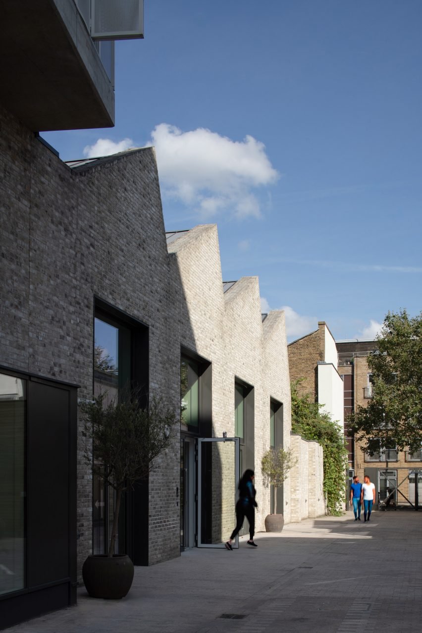 Кирпичный жилой дом и художественное здание с зубчатой ​​крышей от Coffey Architects.