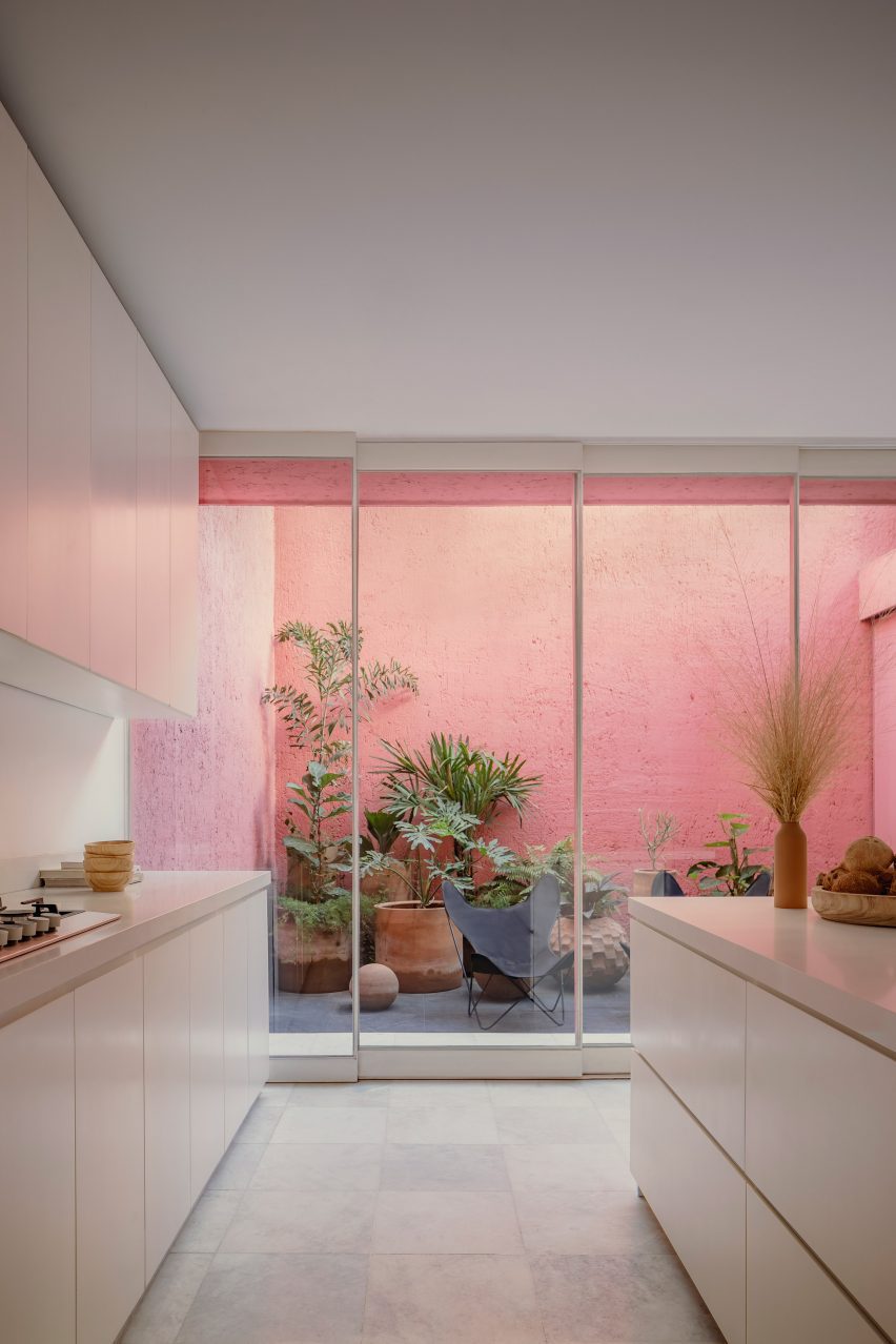 Кухня с видом на горшечный сад с розовыми стенами