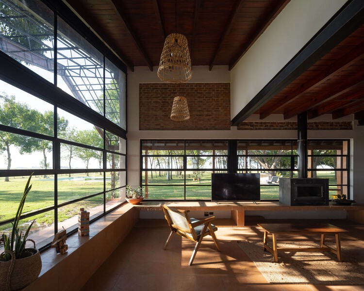 Загородный дом в Пиле / DRM Arquitectura - Фотография интерьера, стол, окна, стул, балка
