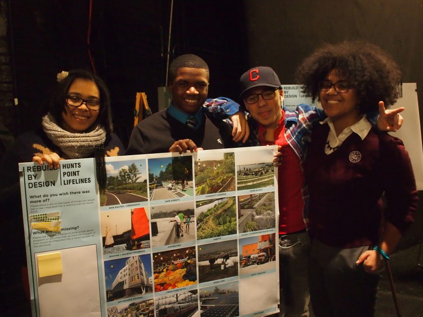 Фотография четырех подростков, держащих в руках плакат с презентацией. 
