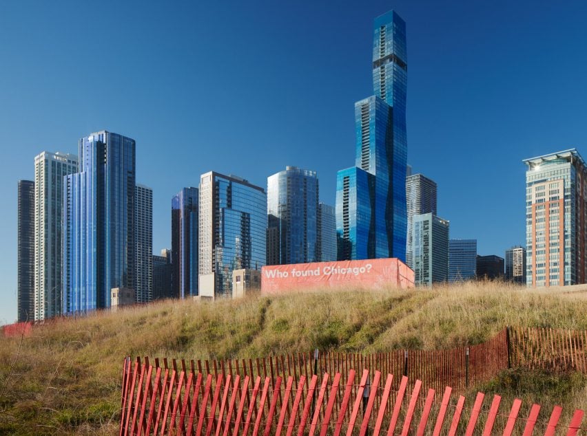 Оранжевый павильон с текстом «Кто нашел Чикаго?»  На фоне горизонта Чикаго