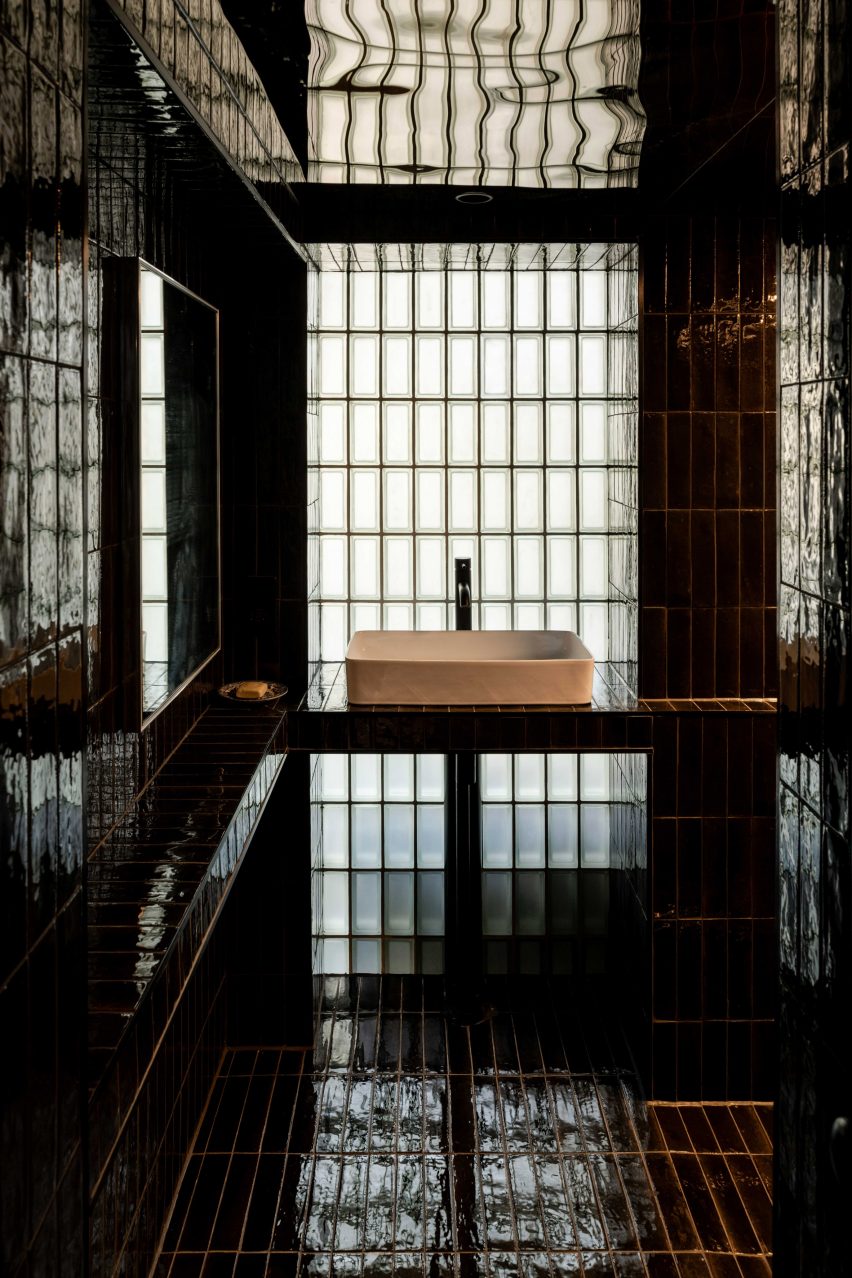 Ванная комната с черной плиткой в ​​квартире Walden от Polysmiths
