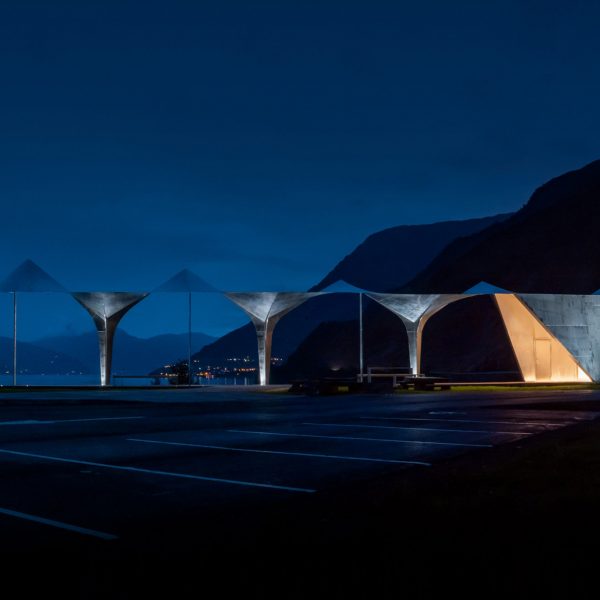 Световое бюро тонко освещает остановку для отдыха на берегу фьорда в Норвегии
