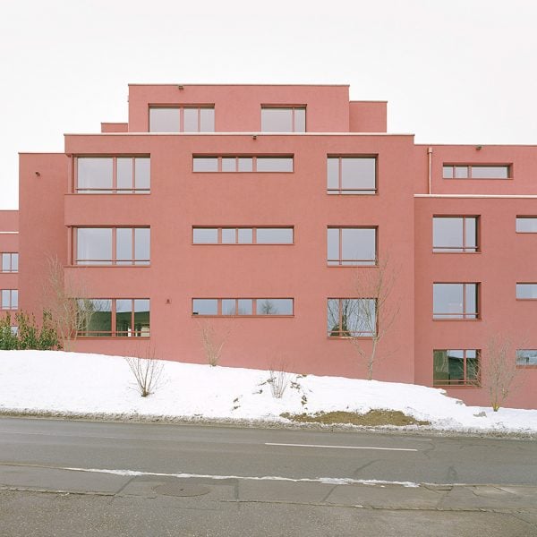 Ductus покрыл многоквартирный жилой комплекс красной штукатуркой в ​​Швейцарии