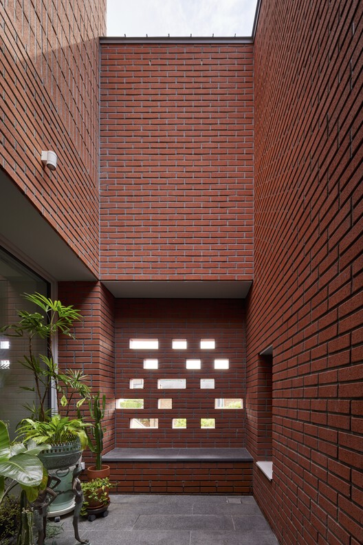 Дом Чокодже / НОМАЛ - Фотография интерьера, кирпич, фасад, окна