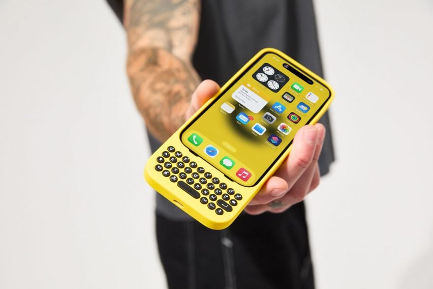 Человек, держащий iPhone с желтой механической клавиатурой