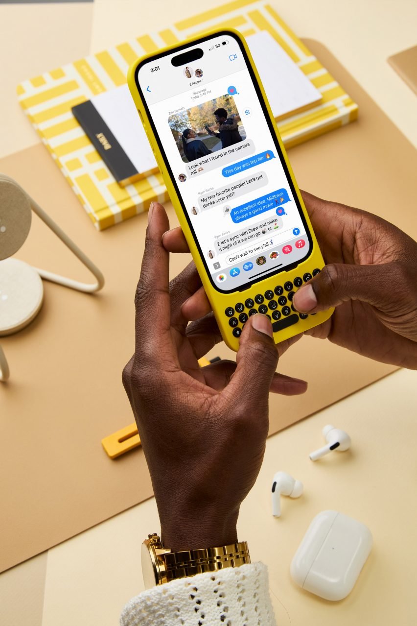 Человек, использующий iPhone с желтой механической клавиатурой от Clicks Technology
