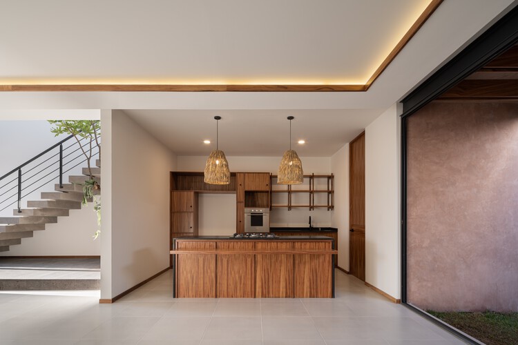 Монолитный Дом / Infante Arquitectos - Фотография интерьера, кухня, столешница, стул, освещение, стол, лестница, балка