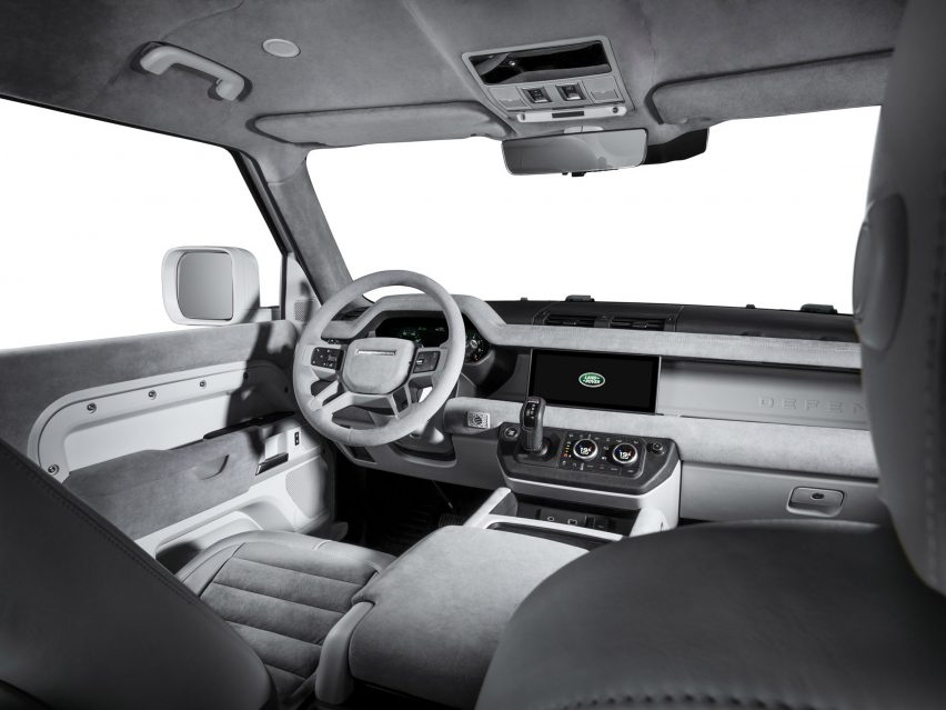 Изображение салона Land Rover Defender Firmship с монохромной светло-серой отделкой, включая кожаные и тканевые сиденья с горизонтальными ребрами. 