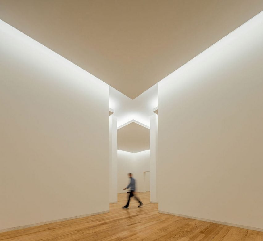 Интерьер галереи с белыми стенами и деревянным полом