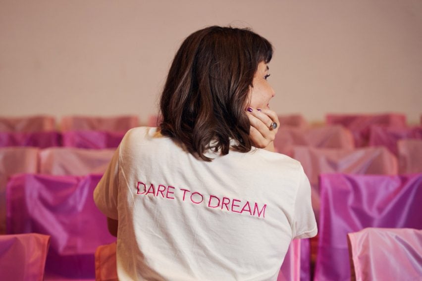 Женщина в футболке с надписью «Смейте мечтать» на спине