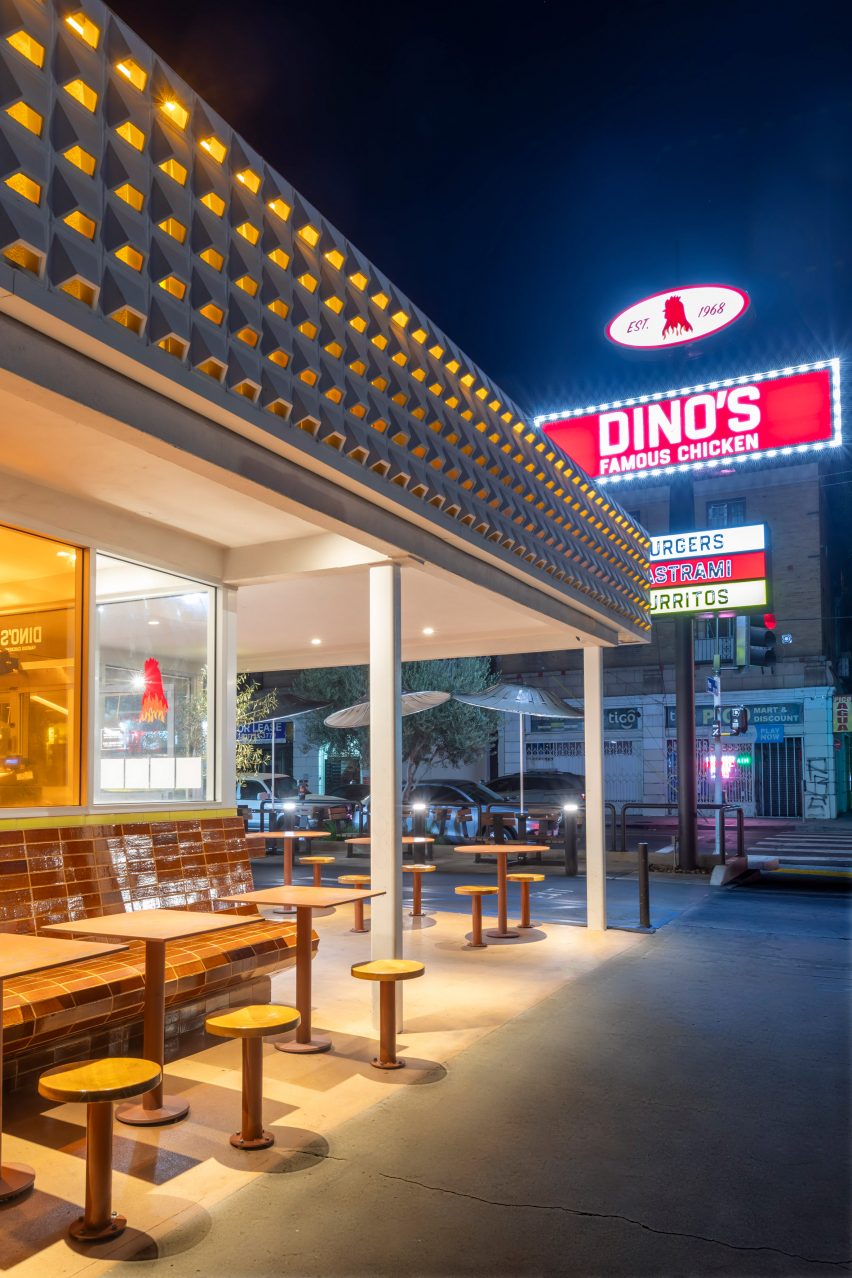 Внешний вид знаменитого куриного магазина Дино ночью с большой вывеской на заднем плане