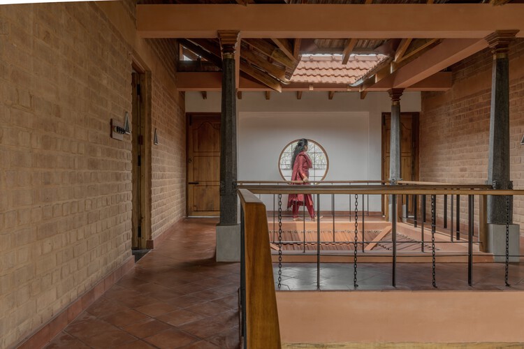 Brick Manor / Архитектурная студия Bhutha Earthen - Фотография интерьера, балка, стул, арка, перила