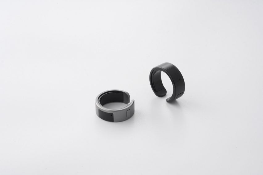 Фотография двух умных колец WIZPR на белой поверхности: серебряного и черного.