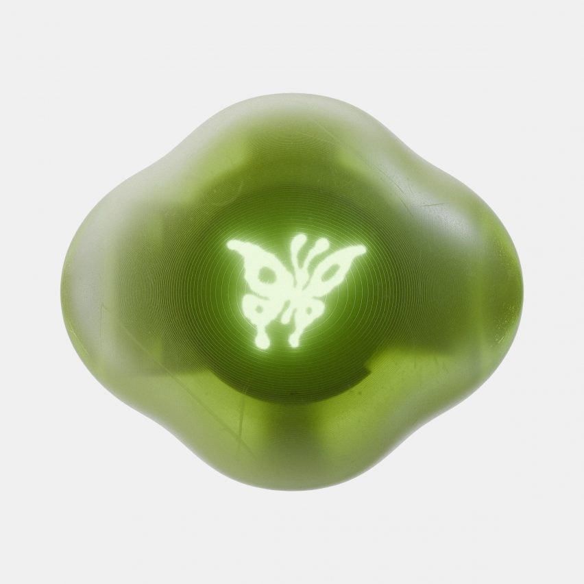 Фотография продукта зеленого устройства Terra со светящимся символом бабочки.