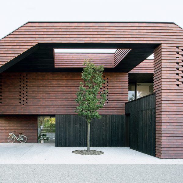 OFIS Arhitekti облицовала геометрический каркасный дом в Словении плиткой из красного кирпича