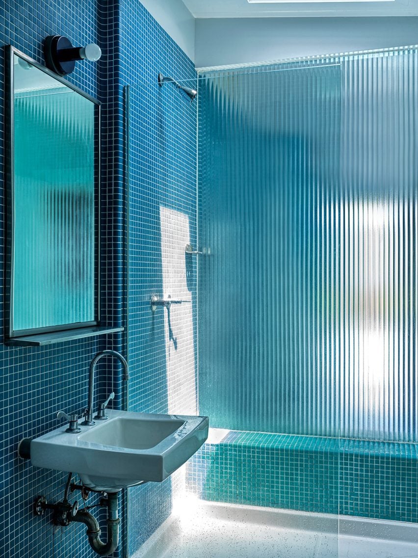 Ванная комната, отделанная синей плиткой и фриттованным стеклом