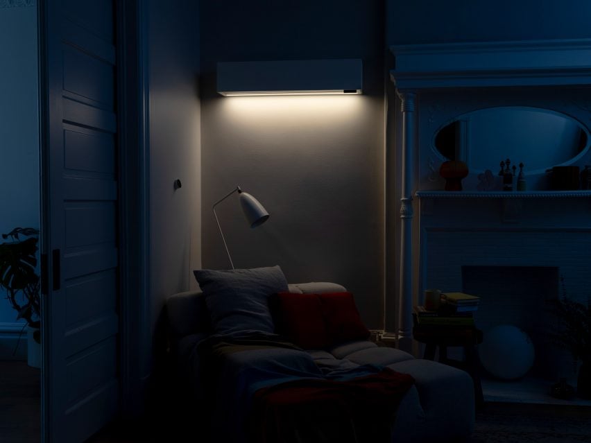 Фотография акцентного света на настенном домашнем климатическом блоке Quilt, освещающего уголок для чтения в темной комнате.