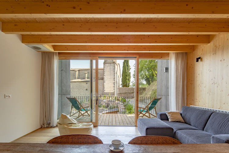 Два дома в Видре / Sau Taller d'Arquitectura — фотография интерьера, гостиная, дерево, балка