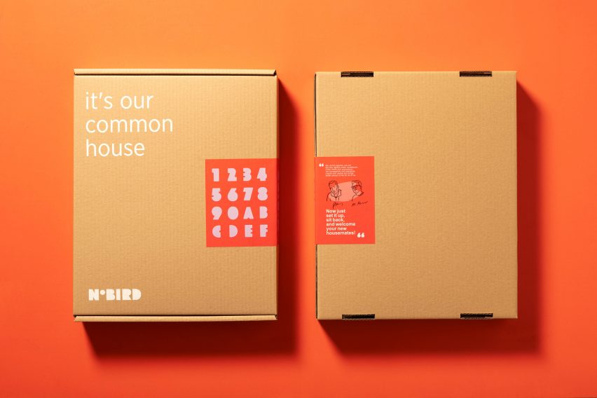 Фотография двух закрытых картонных коробок, расположенных рядом друг с другом на оранжевом фоне.  На одном слева белыми буквами написано: «Это наш общий дом».