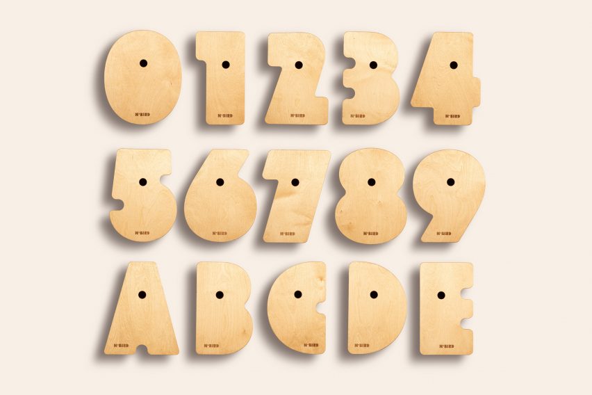 Фотография деревянных цифр от нуля до девяти с деревянными буквами от а до е на белом фоне.
